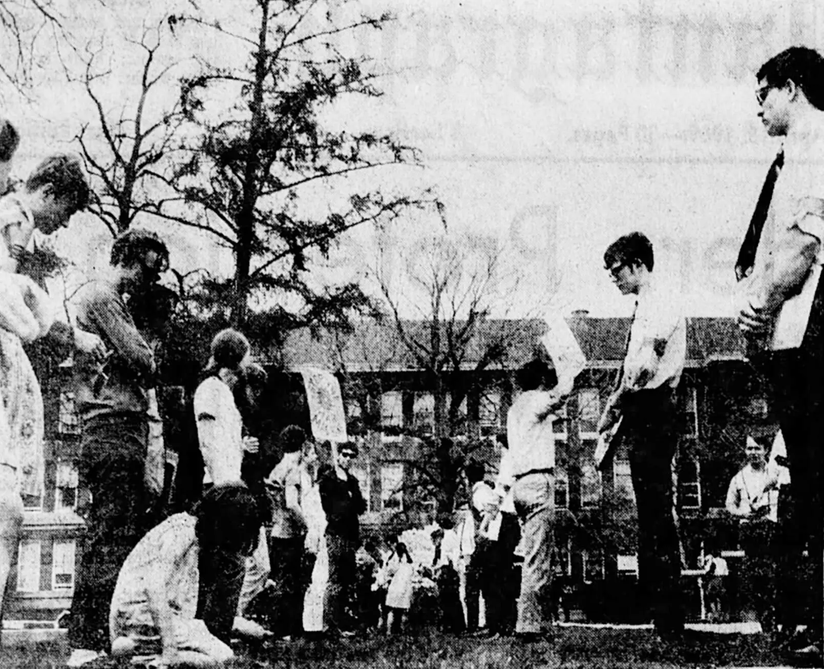 A row of students in white dress shirts and black ties stand facing a row of students dressed in t-shirts and sweatshirts.