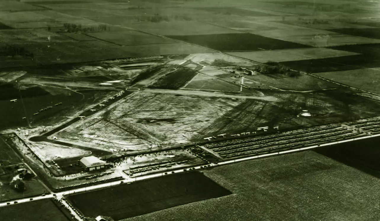 Birds eye view of an airport, and roads, and farm fields.