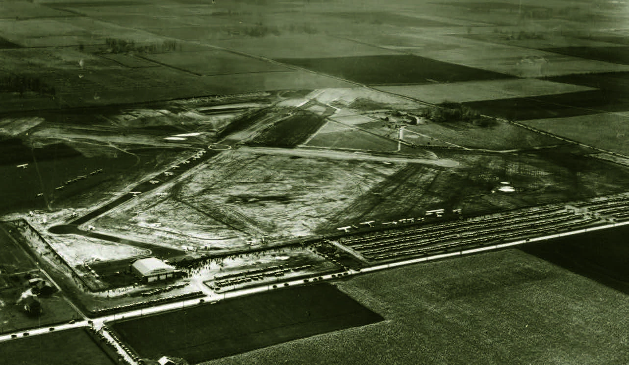 Birds eye view of an airport, and roads, and farm fields.