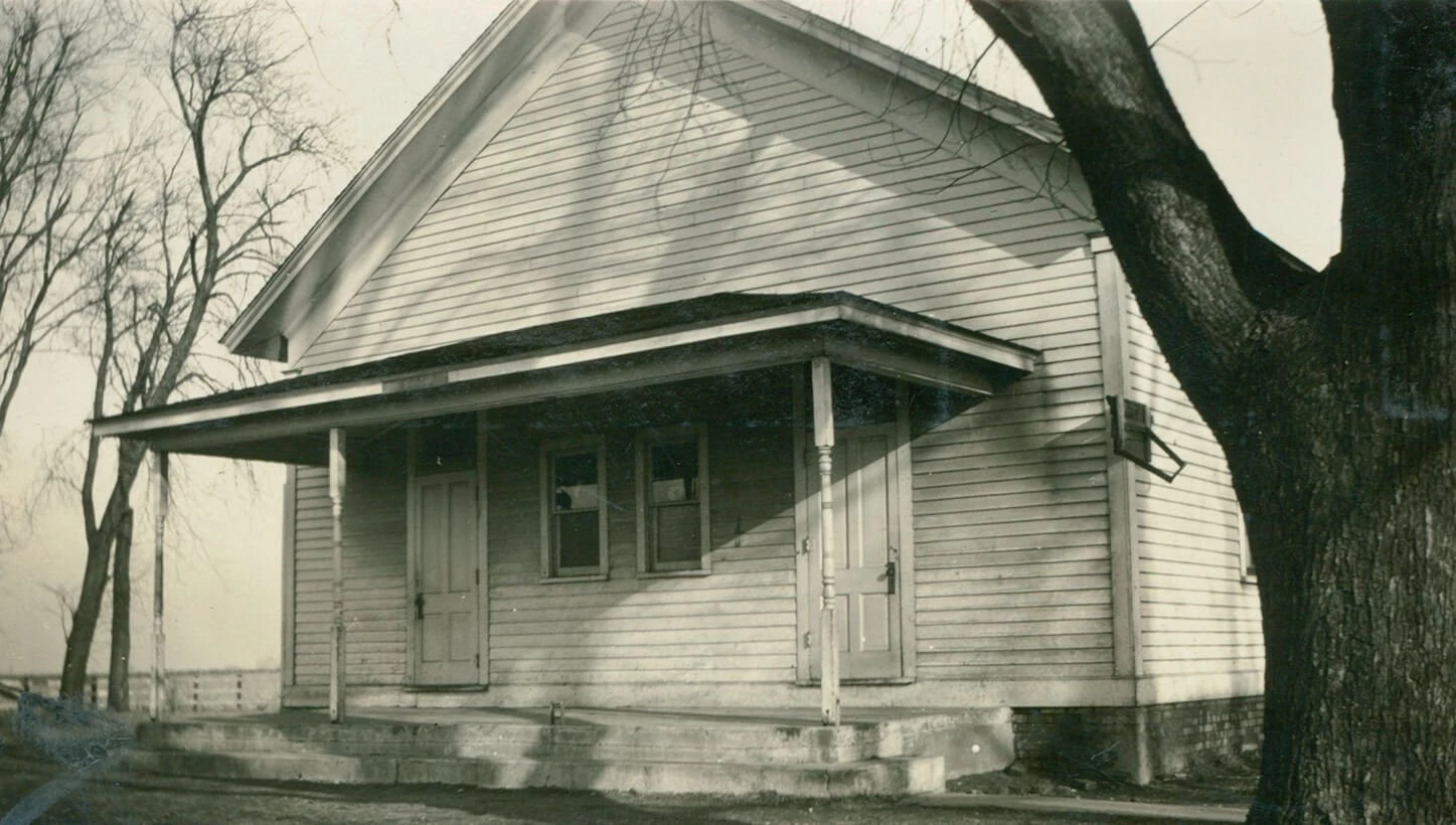 Small wooden house with two doors and wide front porch