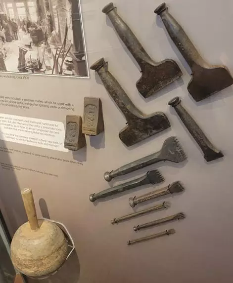 Photo of a set of 10 progressively smaller iron chisels, arranged top to bottom from largest to smallest.