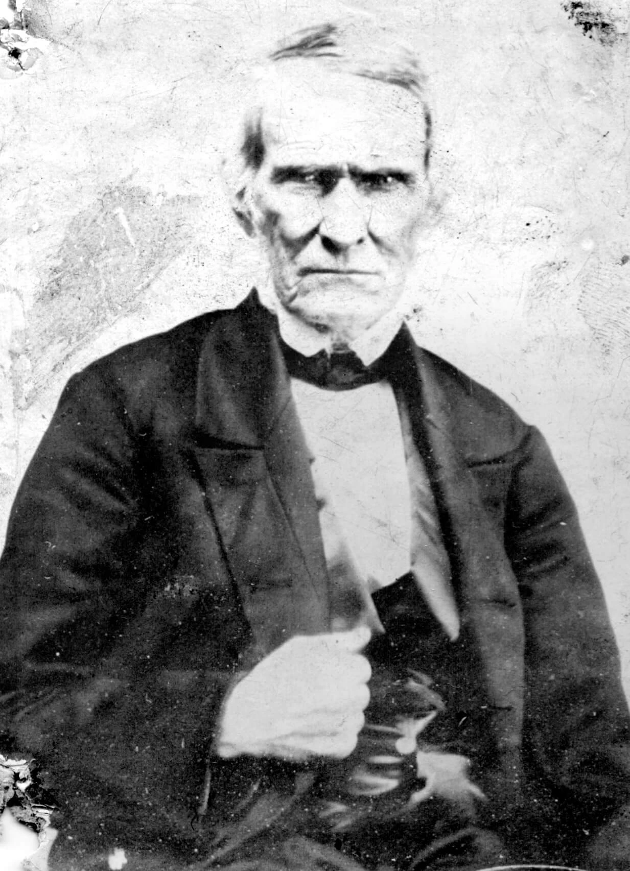 Black and white portrait of an older man, with a hardened face.