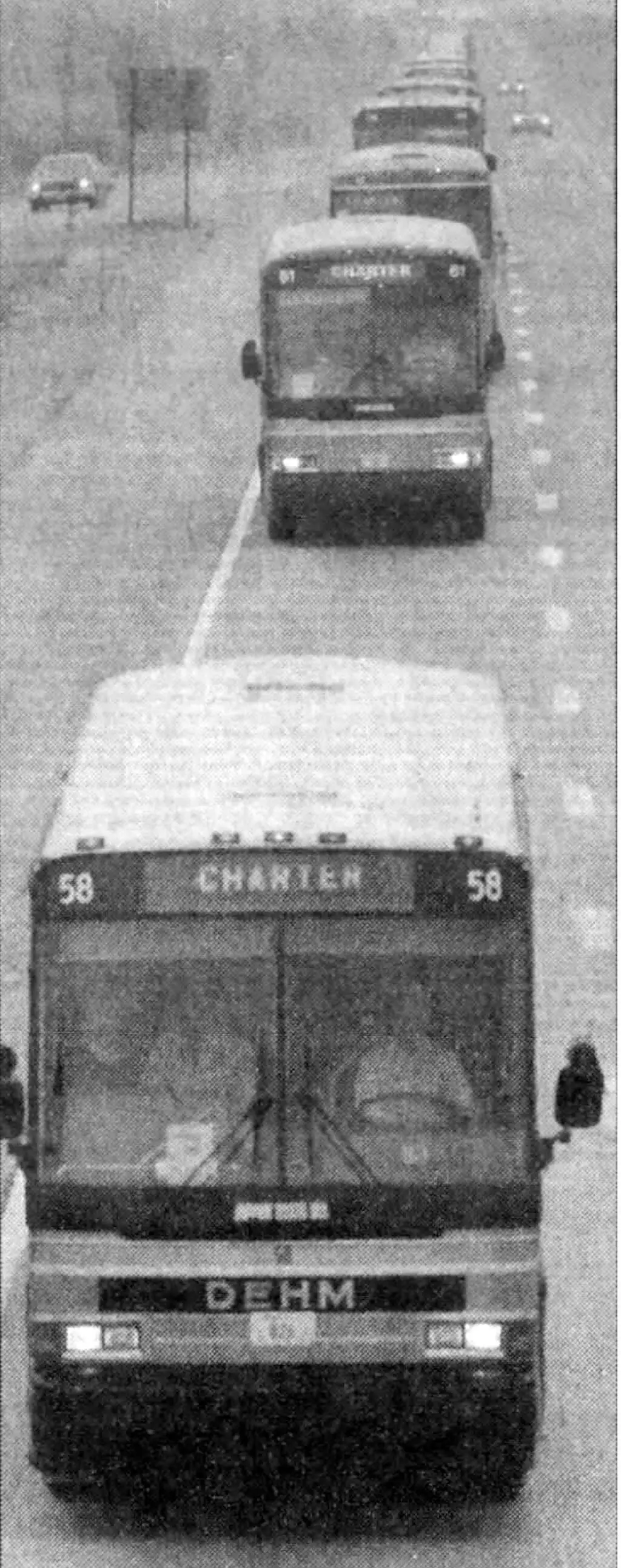 Black and white photo of busses on an interstate.